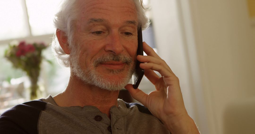 Senior Man Smiling While Talking On Smartphone At Home - Free Images, Stock Photos and Pictures on Pikwizard.com