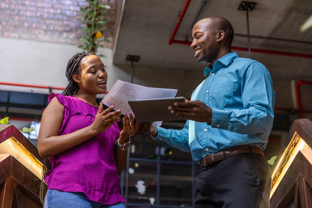 Professionals Collaborating on Office Stairs with Tablet and Documents