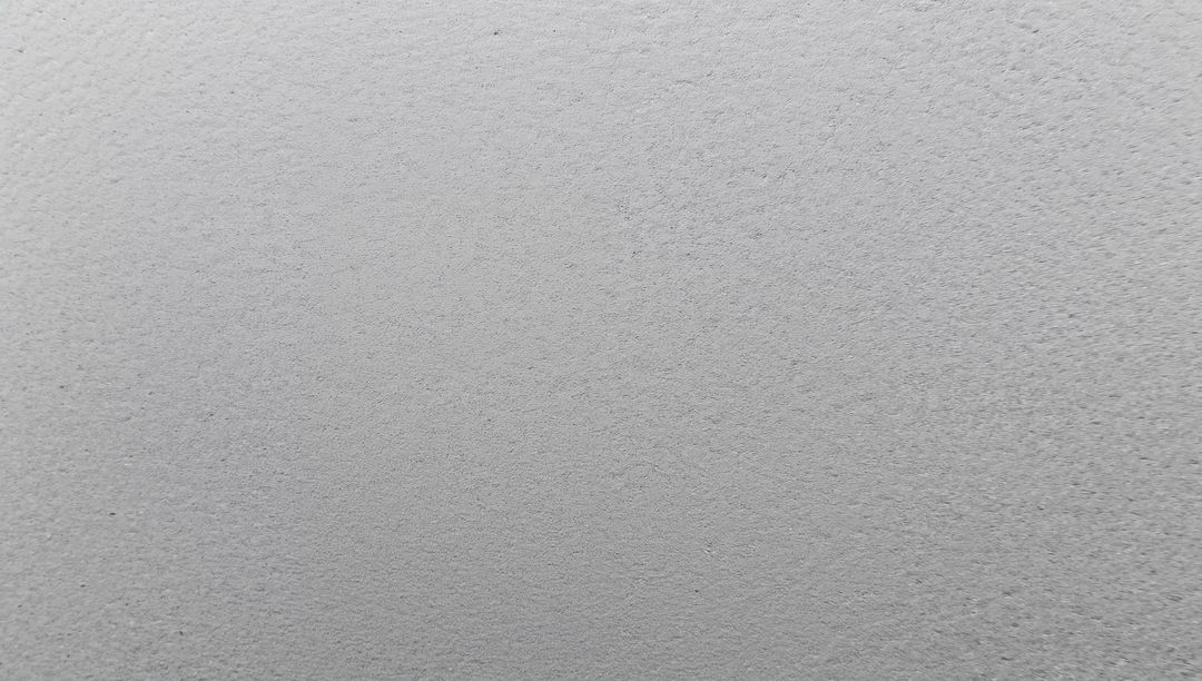 Light gray plaster texture featuring fine speckle and soft tonal gradient, closeup