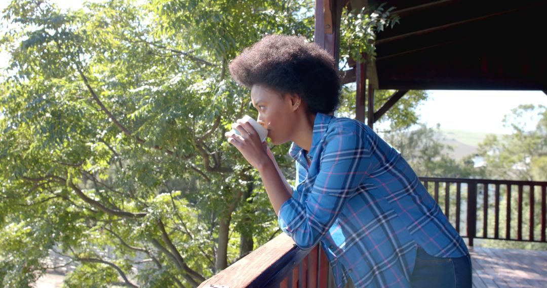 Woman Enjoying Morning Coffee on Balcony Surrounded by Green Trees - Free Images, Stock Photos and Pictures on Pikwizard.com