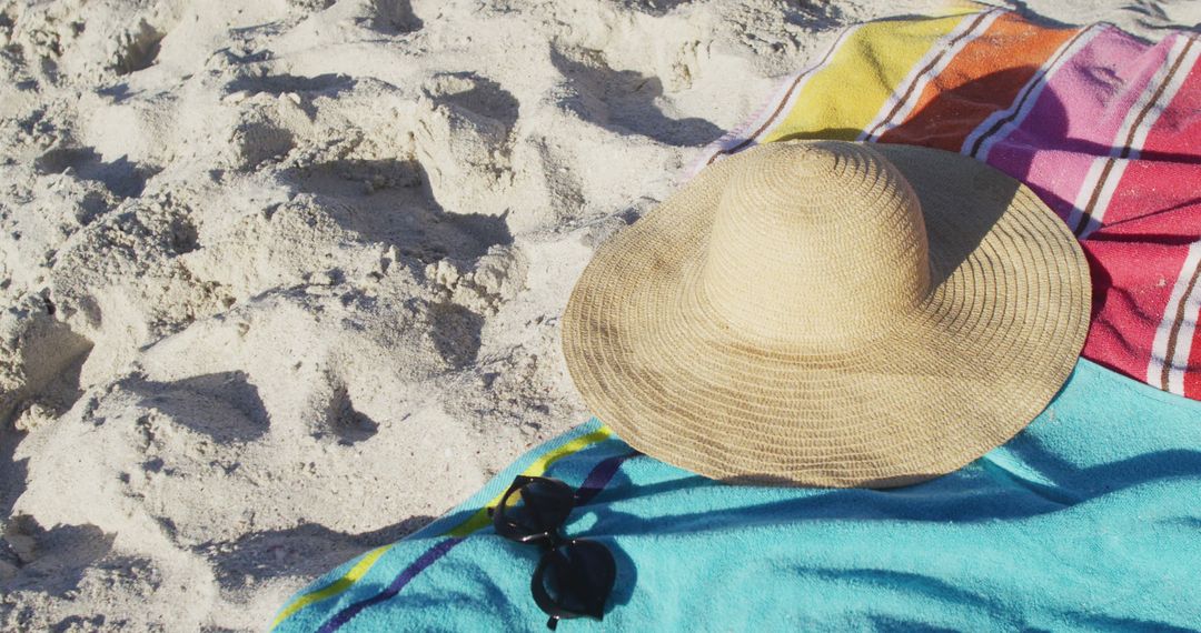 Straw Beach Hat and Towel on Sandy Beach on Sunny Day - Free Images, Stock Photos and Pictures on Pikwizard.com