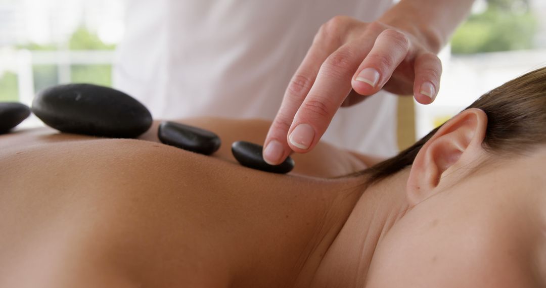 Professional Therapist Placing Hot Stones on Woman's Back for Spa Therapy - Free Images, Stock Photos and Pictures on Pikwizard.com