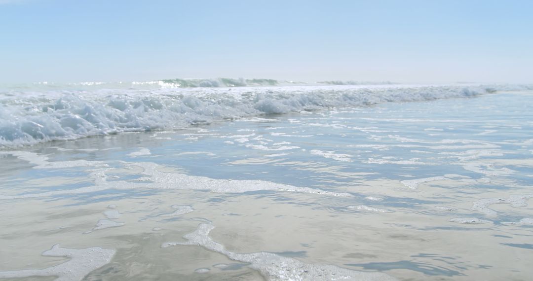 Calm Ocean Waves Gently Lapping Sandy Shoreline Under Clear Sky - Free Images, Stock Photos and Pictures on Pikwizard.com