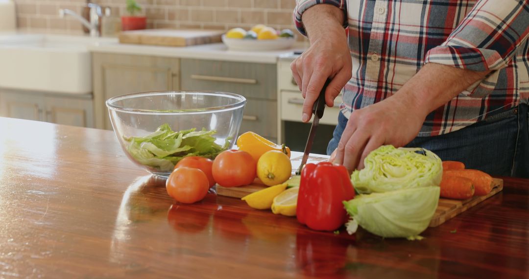 Person preparing fresh vegetables for salad in modern kitchen - Free Images, Stock Photos and Pictures on Pikwizard.com