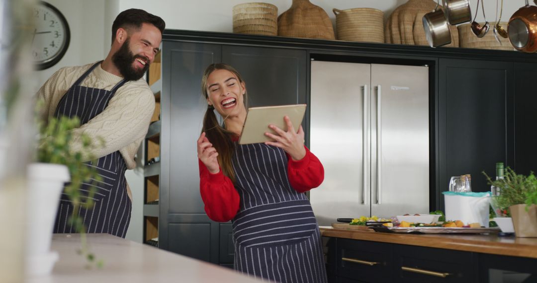 Image of happy caucasian couple using tablet in the kitchen - Free Images, Stock Photos and Pictures on Pikwizard.com