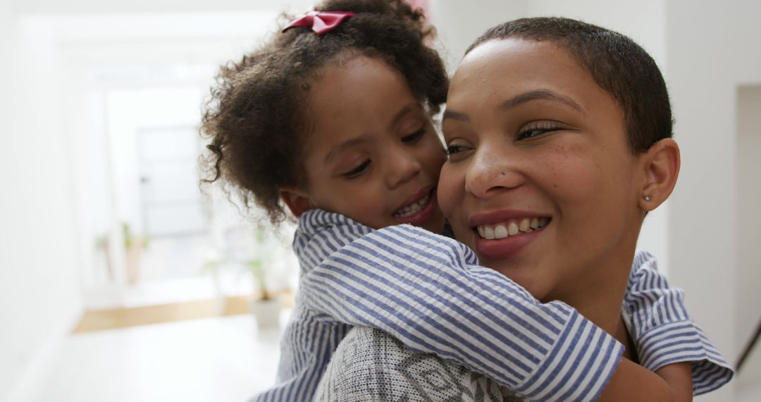 Mother Carrying Daughter at Home Enjoying Time Together