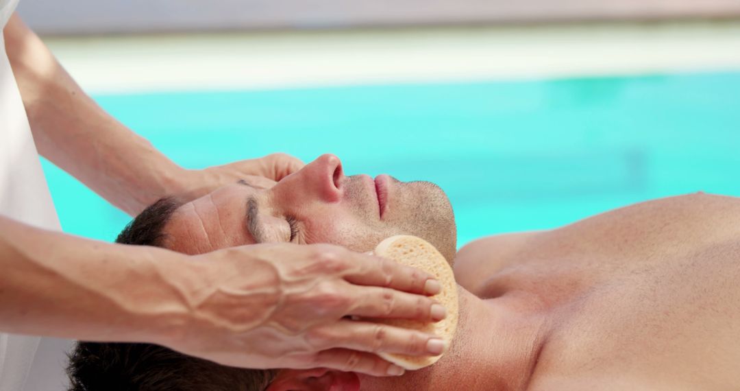 Man Relaxing Poolside Receiving Facial Massage Therapy - Free Images, Stock Photos and Pictures on Pikwizard.com