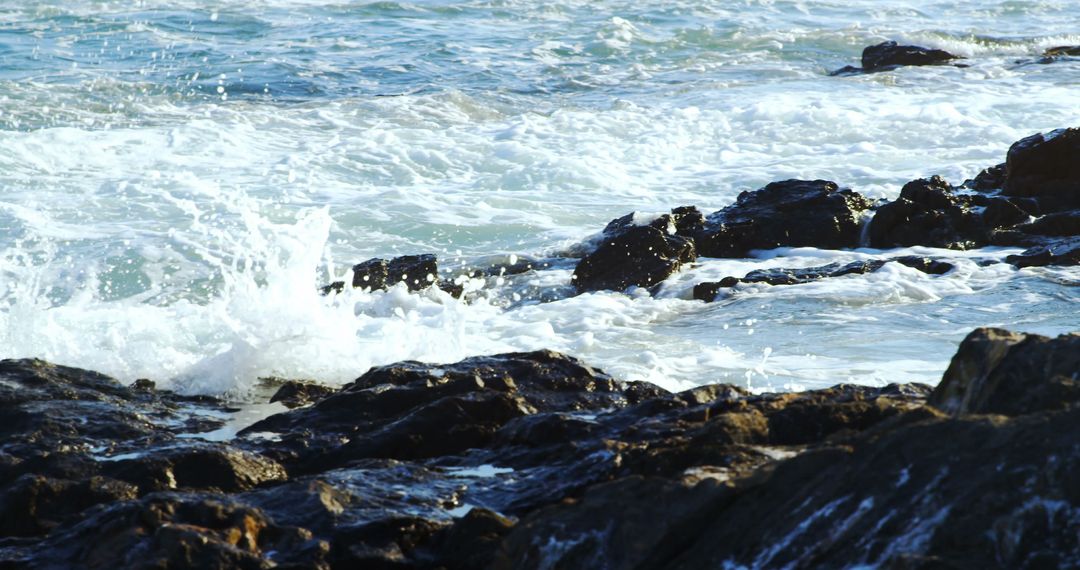 Waves Crashing Against Rocky Shoreline on Sunny Day - Free Images, Stock Photos and Pictures on Pikwizard.com