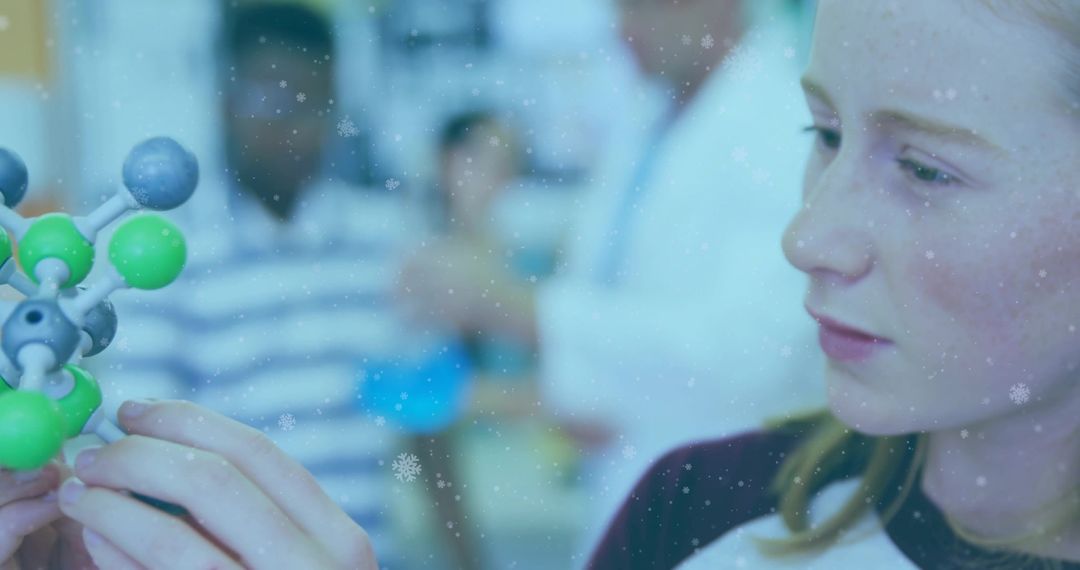 Teen studying molecular model in science laboratory with instructor guidance