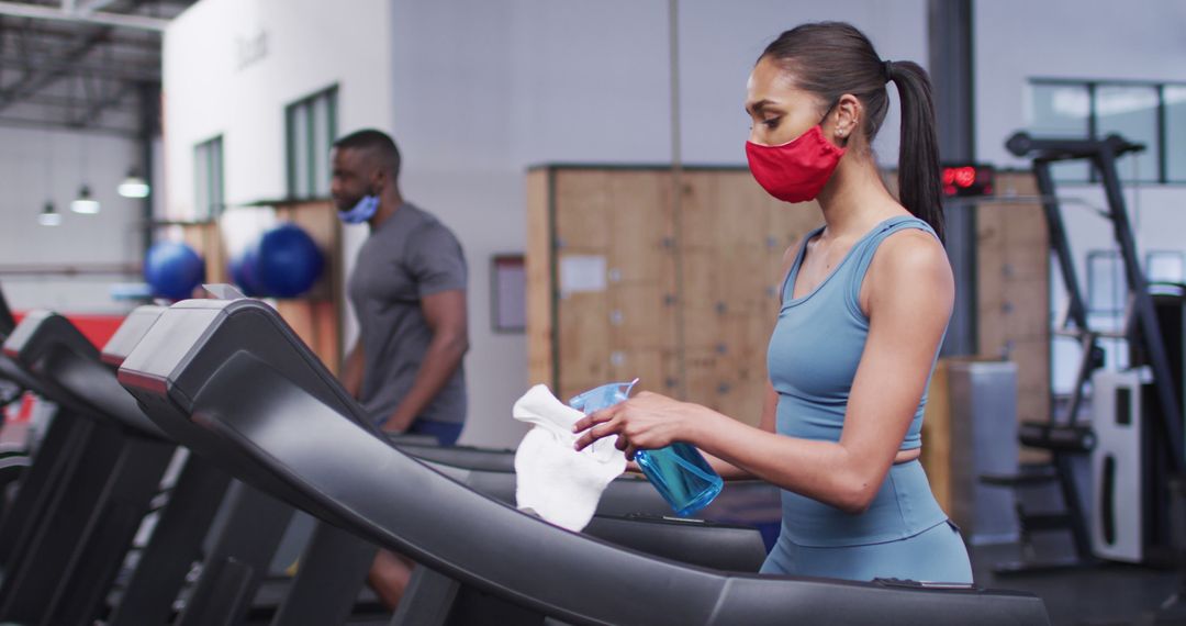 Woman Disinfecting Gym Treadmill with Cloth and Spray, Wearing Athletic Gear and Face Mask - Free Images, Stock Photos and Pictures on Pikwizard.com