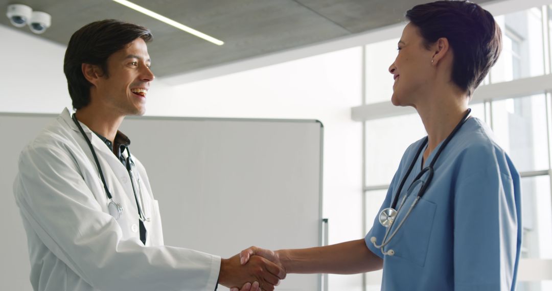 Healthcare Professionals Shaking Hands in Medical Facility - Free Images, Stock Photos and Pictures on Pikwizard.com