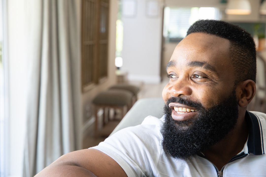 Smiling Man Relaxing Near Window in Cozy Living Room