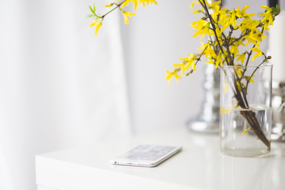 Minimalist White Desk with Smartphone and Yellow Flowers in Vase - Free Images, Stock Photos and Pictures on Pikwizard.com