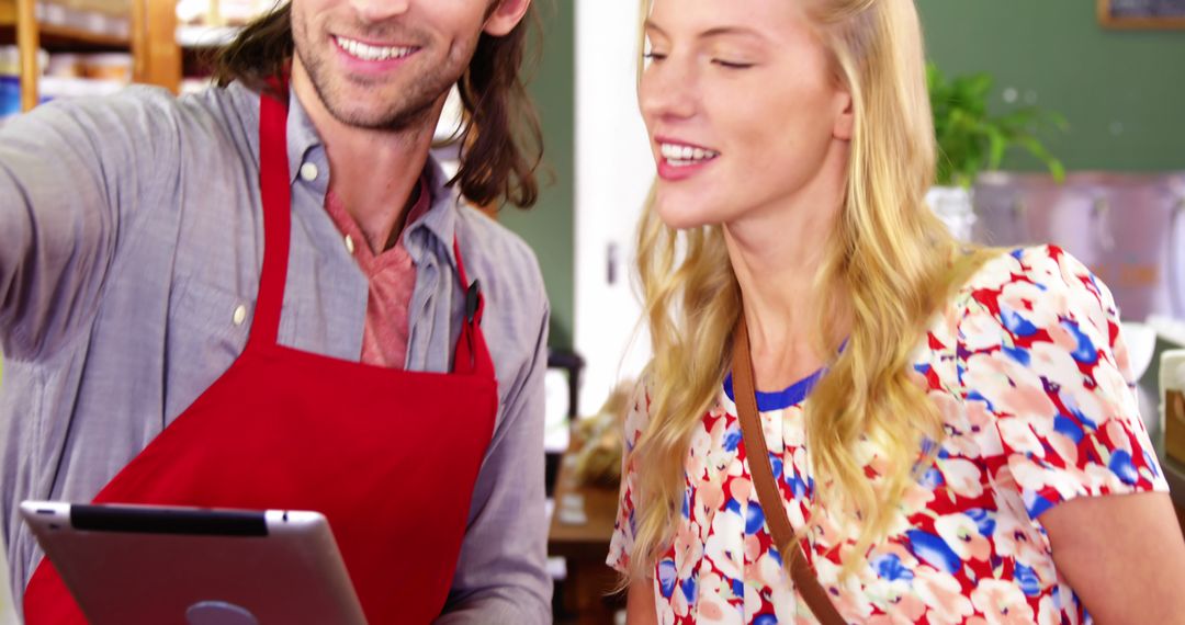 Supermarket Staff Assisting Customer with Digital Tablet