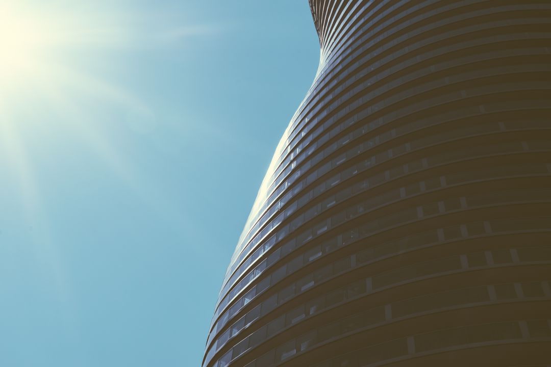 Futuristic Skyscraper with Curved Design and Sunlight - Free Images, Stock Photos and Pictures on Pikwizard.com