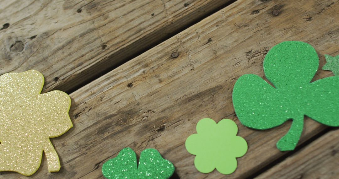 Glittering Shamrocks Cutouts on Rustic Wooden Surface - Free Images, Stock Photos and Pictures on Pikwizard.com