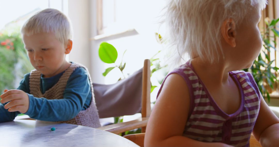 Blonde Children Having Fun at Home Seated at Table