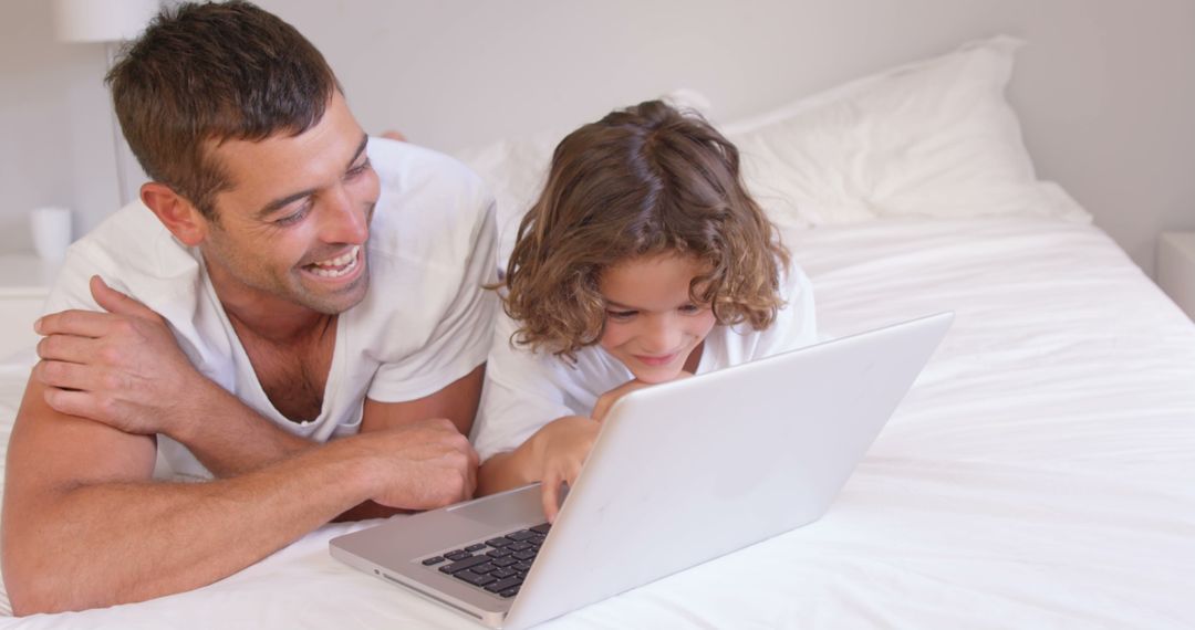 Father and Daughter Using Laptop on Bed, Smiling and Spending Quality Time Together - Free Images, Stock Photos and Pictures on Pikwizard.com