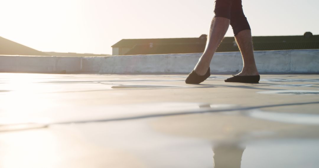 Person Walking on Rooftop at Sunset with Shadows - Free Images, Stock Photos and Pictures on Pikwizard.com