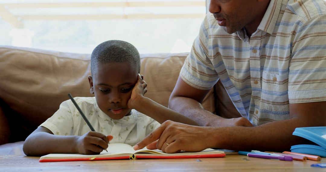 Father Helping Son with Homework on Couch - Free Images, Stock Photos and Pictures on Pikwizard.com