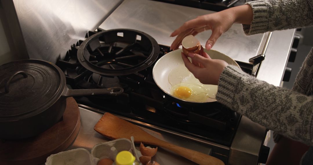 Person Cracking Egg into Frying Pan on Stove - Free Images, Stock Photos and Pictures on Pikwizard.com