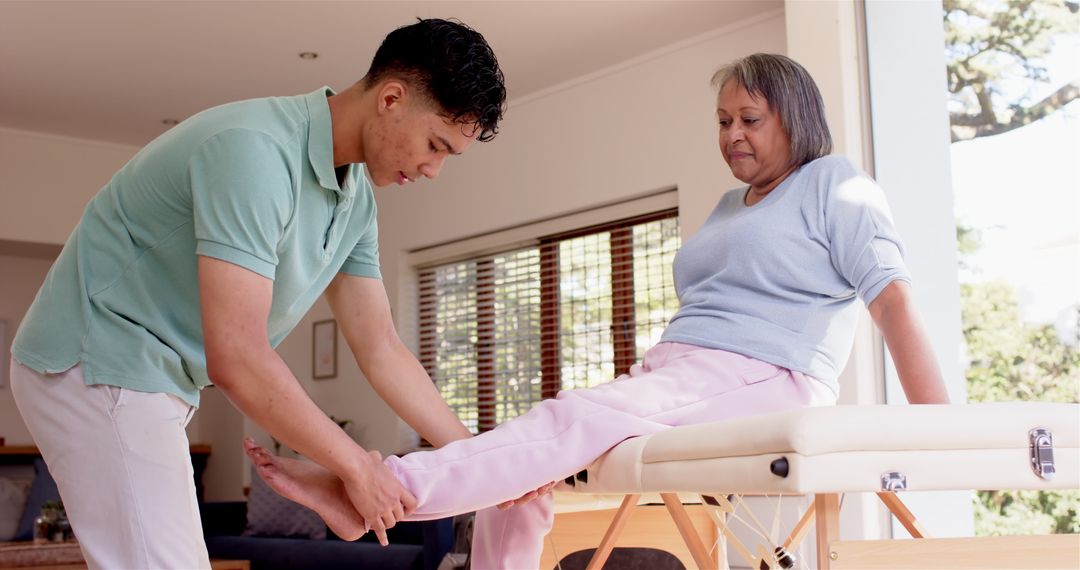 Physiotherapist Assisting Senior Woman with Leg Exercises Indoors