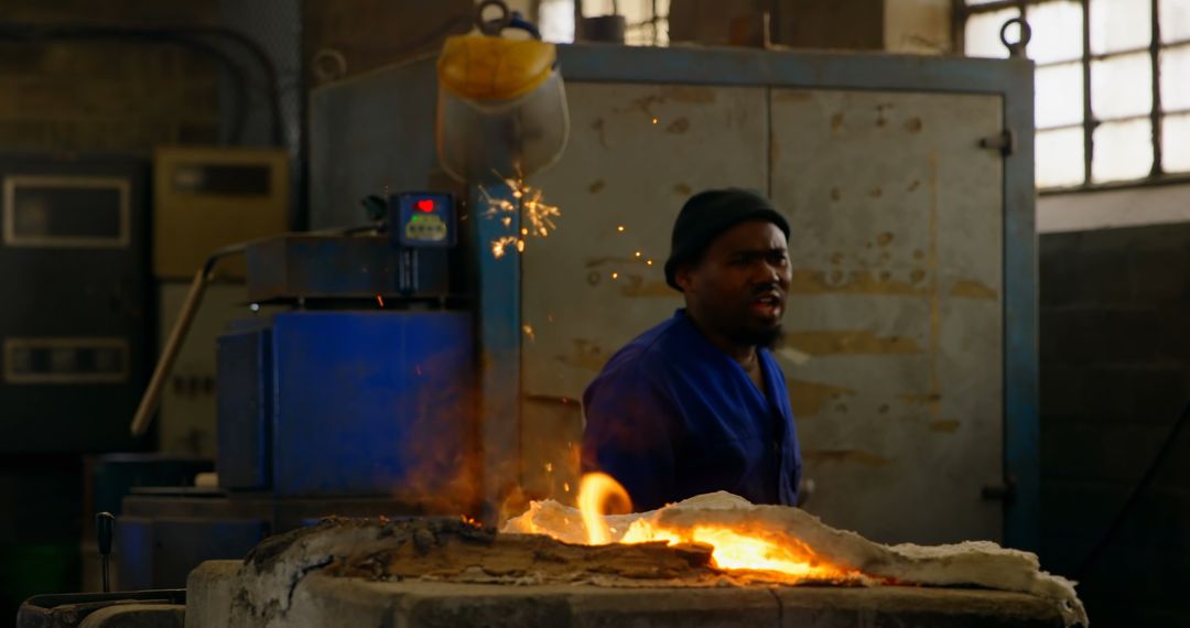 Metalworker Amidst Sparks and Flames in Forging Workshop