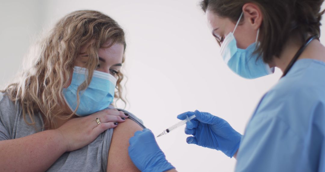 Healthcare Worker Administering Vaccine to Young Woman in Medical Mask - Free Images, Stock Photos and Pictures on Pikwizard.com