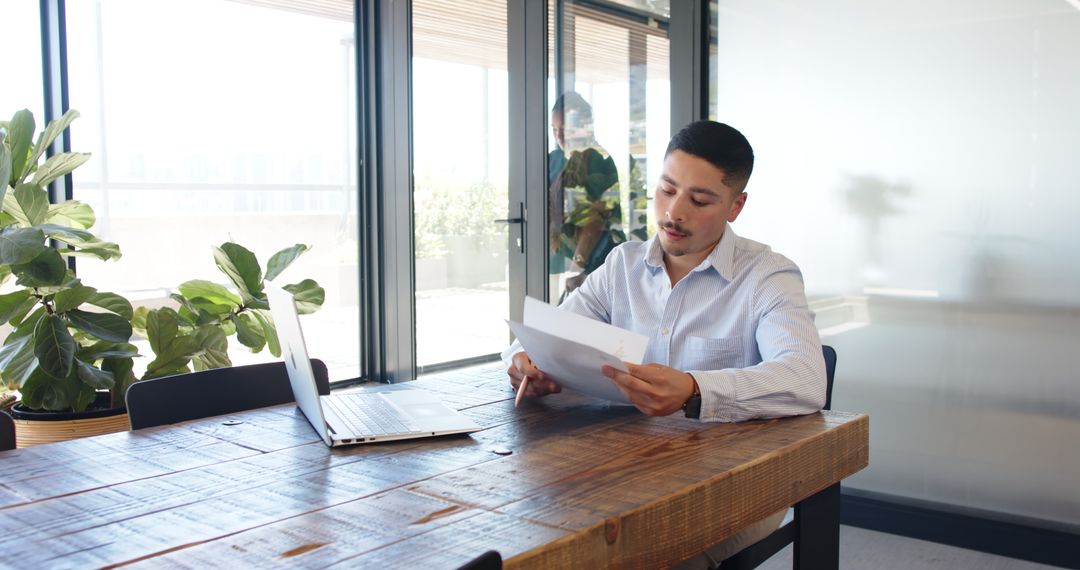 Young Professional Analyzing Documents at Rustic Table