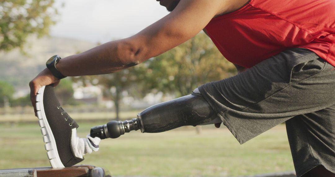 Disabled African American Man Stretching with Prosthetic Leg Outdoors - Free Images, Stock Photos and Pictures on Pikwizard.com