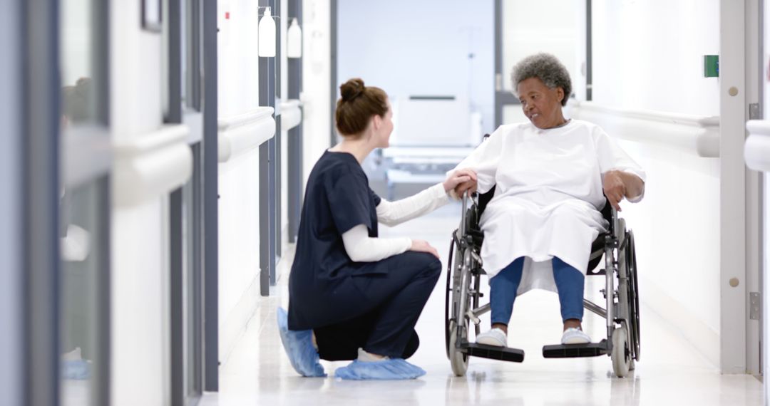 Nurse Assisting Elderly Patient in Hospital Corridor - Free Images, Stock Photos and Pictures on Pikwizard.com