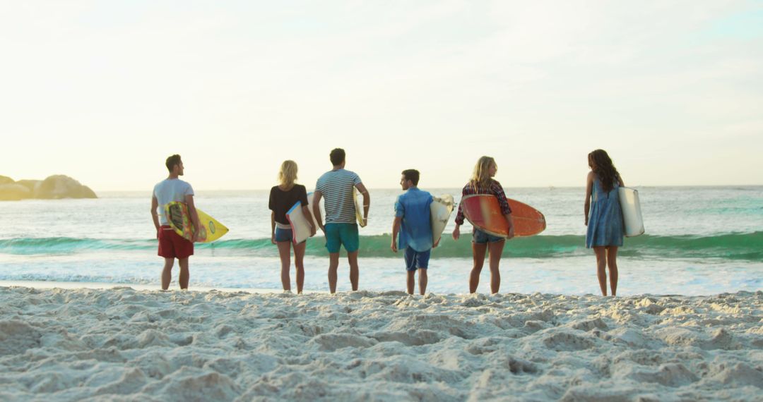 Friends Ready for Surfing on Sandy Beach at Sunset - Free Images, Stock Photos and Pictures on Pikwizard.com