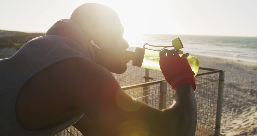 Athletic Man Drinking from Water Bottle after Beach Workout - Free Images, Stock Photos and Pictures on Pikwizard.com