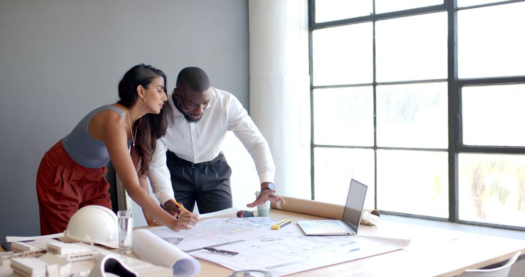 Architects Collaborating on Blueprint Plans in Office Setting