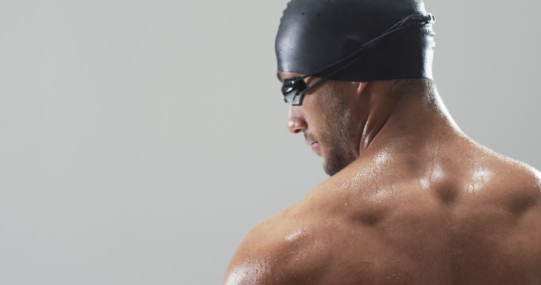 Swimmer in Black Cap Emphasizing Athletic Focus and Strength