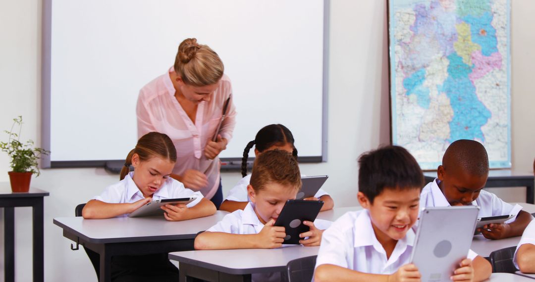 Children Using Tablets During a Classroom Activity with Teacher Assistance - Free Images, Stock Photos and Pictures on Pikwizard.com