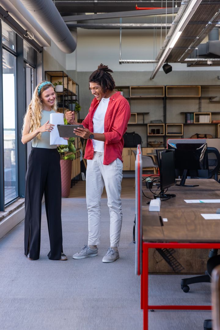 Diverse Coworkers Discussing Data in Modern Open-Plan Office