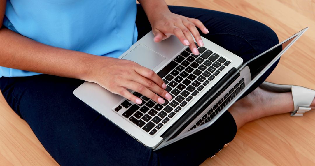 Person Typing on Laptop Sitting on Wooden Floor - Free Images, Stock Photos and Pictures on Pikwizard.com