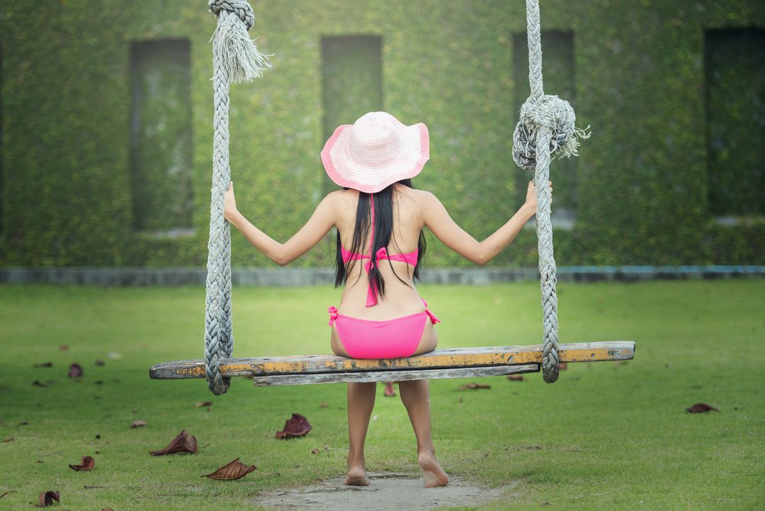 Woman in Pink Bikini Hat Relaxing on Tree Swing in Sunny Garden - Free Images, Stock Photos and Pictures on Pikwizard.com