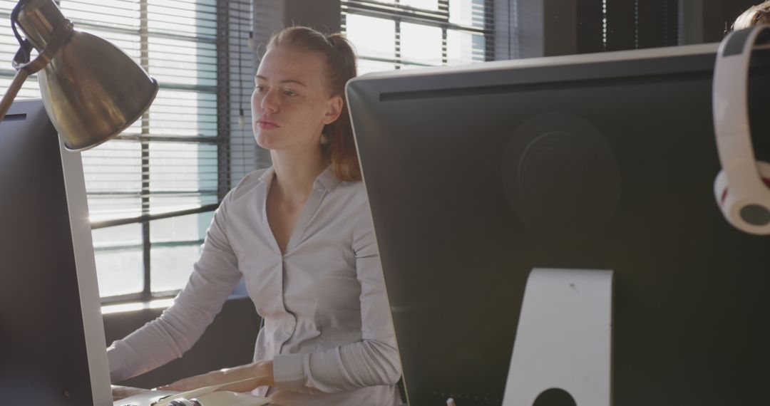 Caucasian Businesswoman Working at Computer in Bright Modern Office