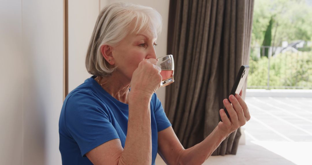 Senior Woman Enjoying Beverage while Using Smartphone