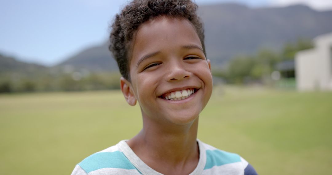 Joyful Biracial Boy Smiling in Sunny Field