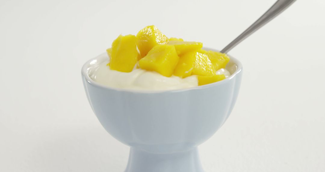 A bowl of creamy yogurt topped with diced mango offers a healthy snack option, with copy space - Free Images, Stock Photos and Pictures on Pikwizard.com