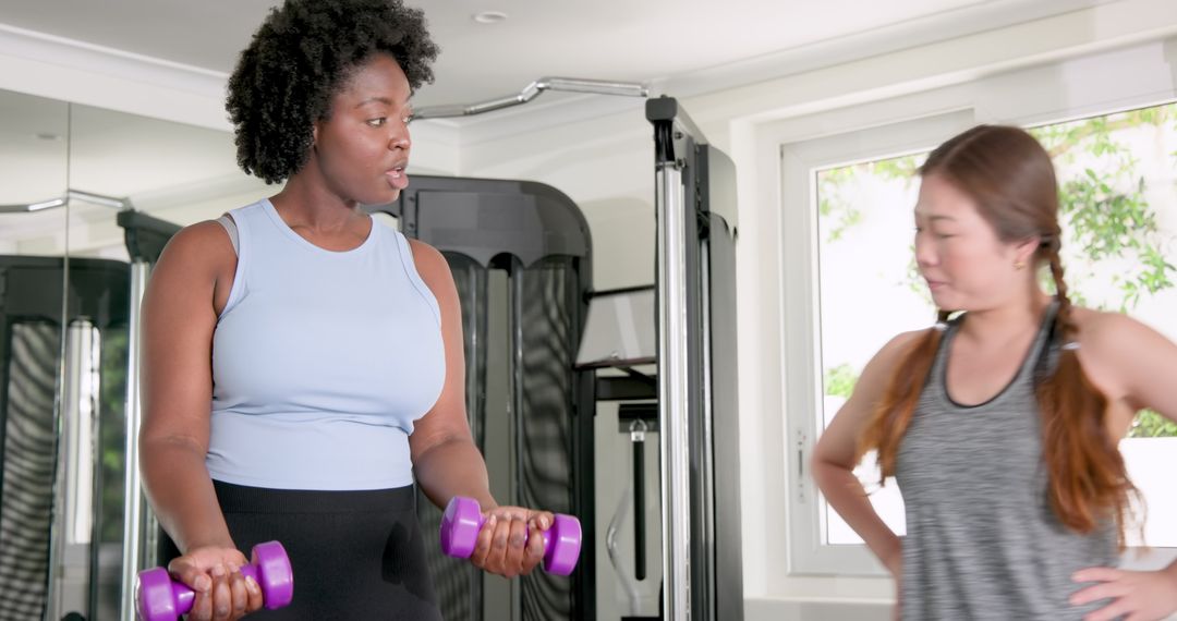 Female Trainer Instructing Partner with Dumbbells in Gym