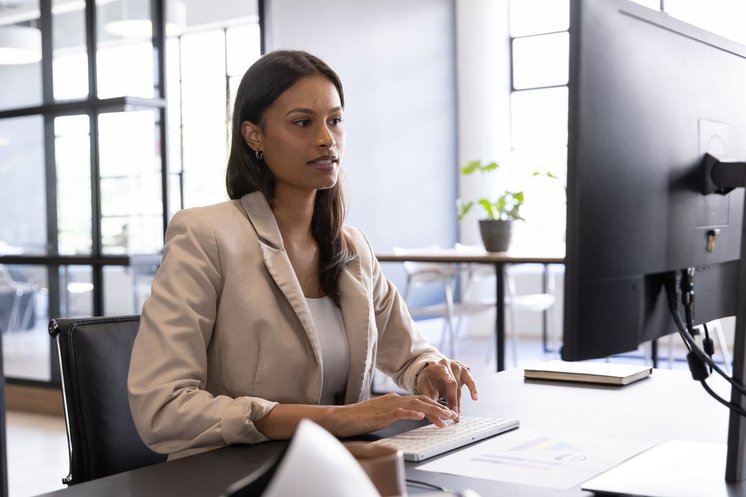 Focused Asian Businesswoman Typing in Modern Office