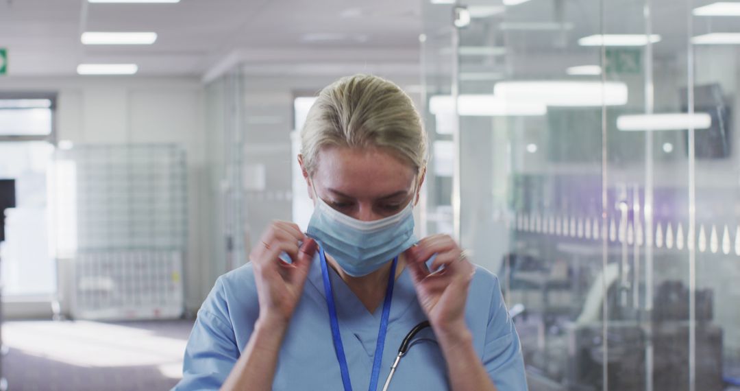 Healthcare Worker Adjusting Face Mask in Hospital Setting - Free Images, Stock Photos and Pictures on Pikwizard.com