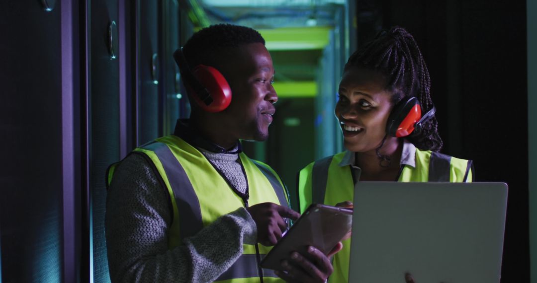 IT Engineers Discussing in Server Room With Protective Gear
