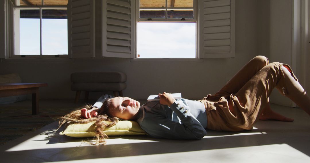 Woman Relaxing on Floor Reading Book by Window with Open Shutters - Free Images, Stock Photos and Pictures on Pikwizard.com