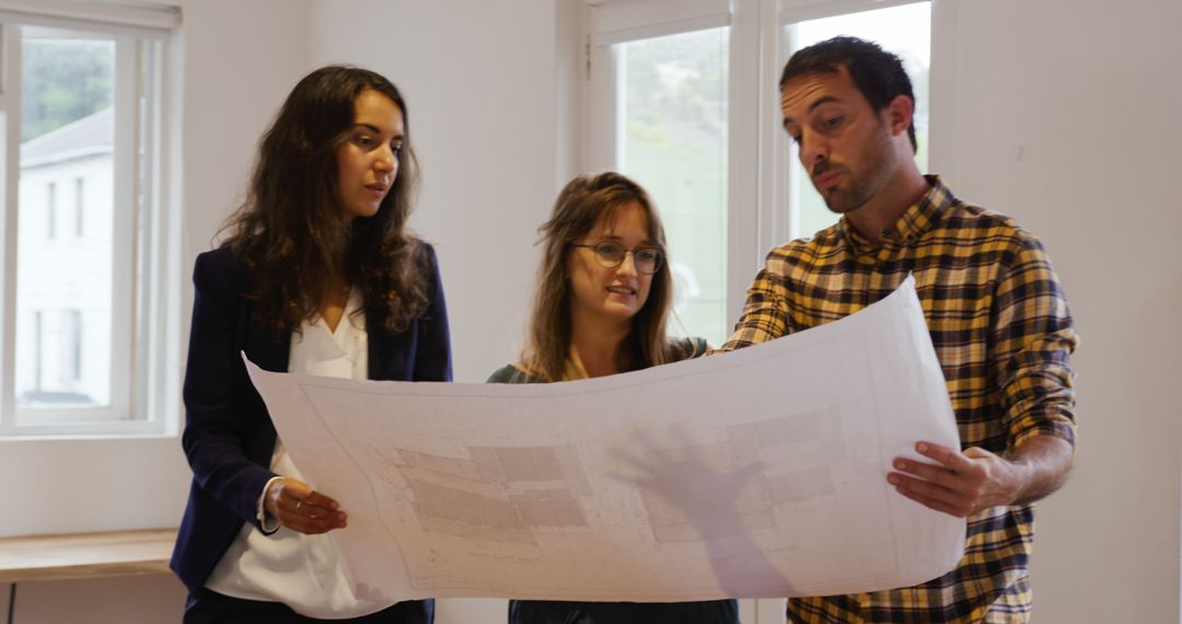 Architectural Team Discussing Building Blueprints in Office - Free Images, Stock Photos and Pictures on Pikwizard.com