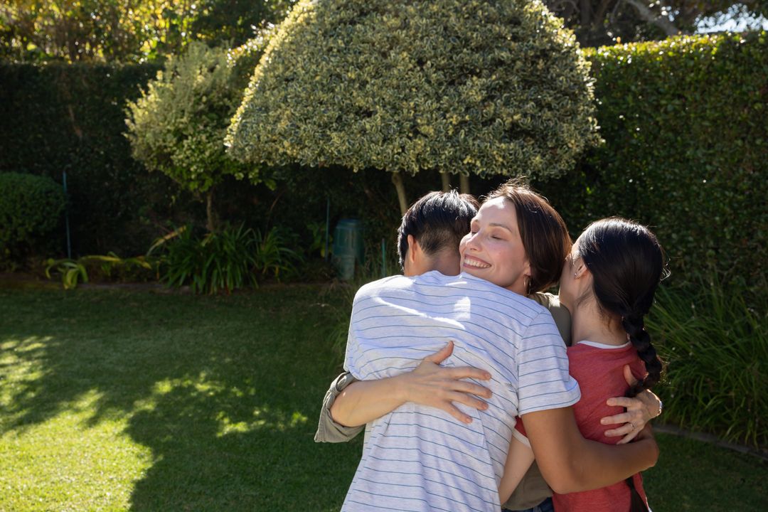 Happy Family Hugging in Backyard Garden
